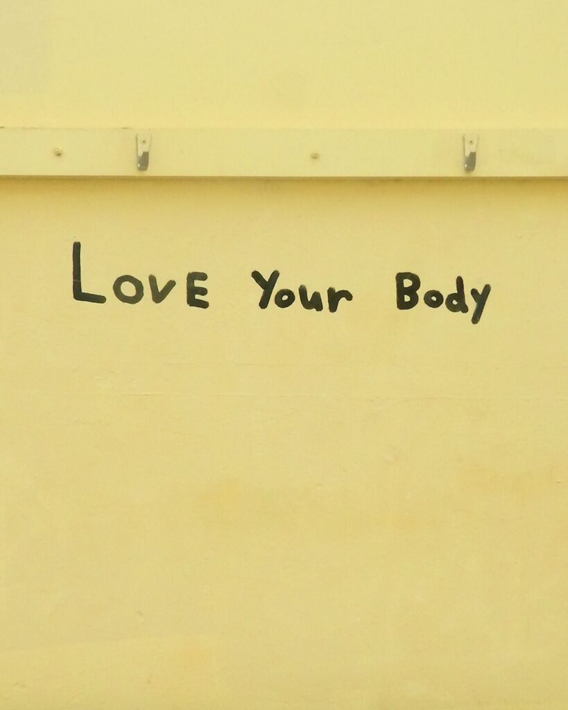 Love your body,Positive body image message handwrtten on yellow wall